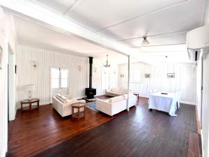 a living room with white furniture and a fireplace at The Cottage Farm Stay - Grandchester in Grandchester