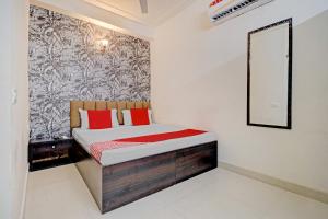 um quarto com uma cama com almofadas vermelhas e um espelho em OYO Hotel Sky View em Ludhiana