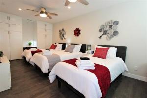 a bedroom with four beds with white and red sheets at Secluded & Quiet Guest House-Cherry Valley-Morongo in Cherry Valley