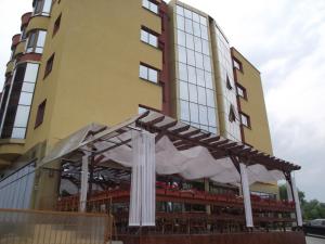 a building with a table and chairs in front of it at Hotel Flormang in Craiova