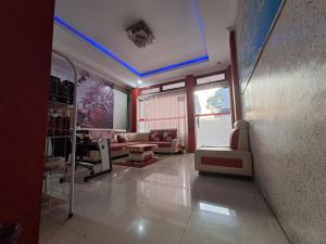 un salon avec une lumière bleue au plafond dans l'établissement Homestay Setiabudi, à Bandung