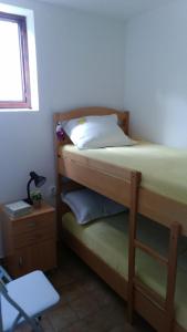 - une chambre avec 2 lits superposés et une chaise dans l'établissement Studio Apartment Jadranko, à Krnica