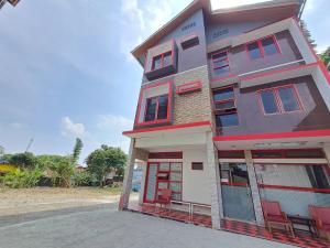 a building with red and white windows on a street at Homestay Setiabudi in Bandung