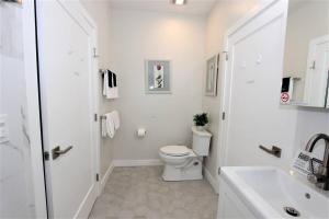 a white bathroom with a toilet and a sink at New & Modern with Accessibility-Family Friendly in San Bernardino