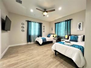 a bedroom with two beds and a ceiling fan at New & Modern with Accessibility-Family Friendly in San Bernardino