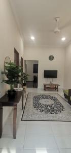 una sala de estar con una maceta sobre una mesa en TEJAH HOMESTAY, en Johor Bahru