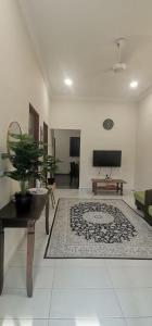 a living room with a table and a rug at TEJAH HOMESTAY in Johor Bahru