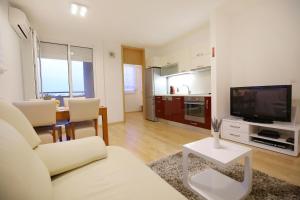 a living room with a couch and a tv and a table at Apartment Marty in Zadar