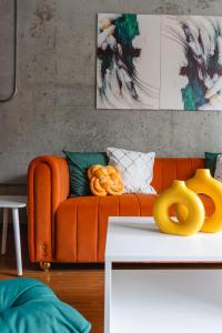 un sofá naranja en una sala de estar con objetos amarillos en Chicago get Away en Chicago
