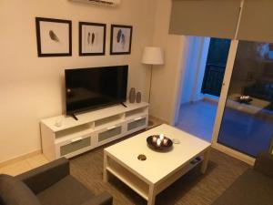 een woonkamer met een televisie en een salontafel bij Artemis Panorama Escape Vacation in Tersephanou