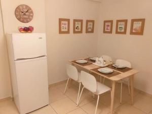 a small kitchen with a table and a refrigerator at Artemis Panorama Escape Vacation in Tersephanou