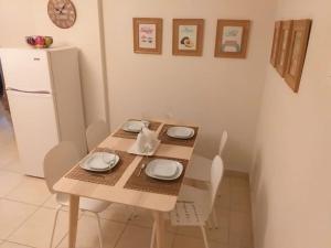 a kitchen with a wooden table with chairs and a refrigerator at Artemis Panorama Escape Vacation in Tersephanou