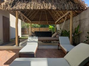 a patio with a hammock and chairs under a thatch roof at CASA CANDRA (HOTEL BOUTIQUE) in San Francisco