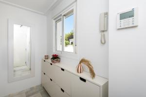 Dieses weiße Zimmer verfügt über eine Kommode und ein Fenster. in der Unterkunft Sea view and 350m to the beach in Torremolinos