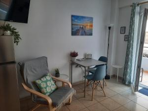 een woonkamer met een tafel en een stoel bij Aelia Studio in Larisa