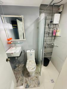 uma casa de banho com um chuveiro, um WC e um lavatório. em Kimura staycation em Angeles