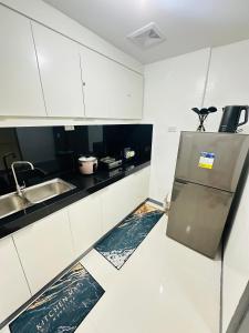 uma cozinha com um lavatório e um frigorífico em Kimura staycation em Angeles