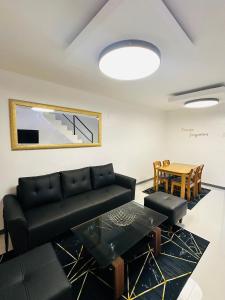 ein Wohnzimmer mit einem schwarzen Sofa und einem Tisch in der Unterkunft Kimura staycation in Angeles