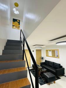 ein Wohnzimmer mit einer Treppe und einer Couch in der Unterkunft Kimura staycation in Angeles