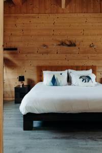 a bedroom with a large bed with a wooden wall at La Villa d'Hélène 2 - Chambres d'hôtes BnB et Appartements - Cluses in Cluses