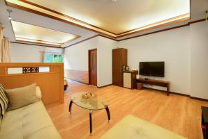 sala de estar con sofá y TV en Hui-Lai Resorts en Jianshi