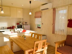 a kitchen and dining room with a wooden table at Tree Village Karuizawa in Karuizawa