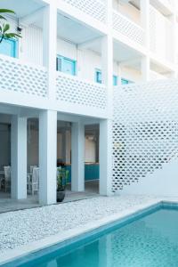 an external view of a building with a swimming pool at Paras Paros Marina Lodge in Sanur