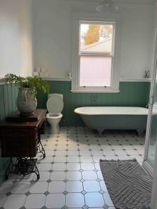 y baño con bañera, aseo y lavamanos. en Breen Green House en Quarry Hill