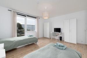 1 Schlafzimmer mit 2 Betten und einem Schreibtisch mit einem TV in der Unterkunft Chic Apartment with balcony in Wolfsburg