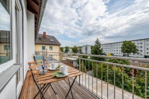 einen Balkon mit einem Holztisch und Aussicht in der Unterkunft Chic Apartment with balcony in Wolfsburg