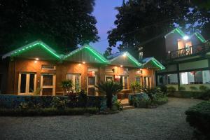 una casa con luces verdes encendidas por la noche en Akarshan Bono Bunglow, en Lataguri