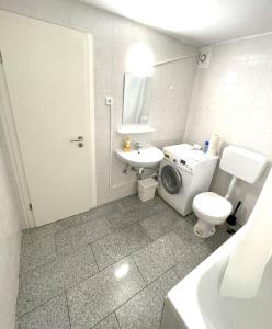 a bathroom with a toilet sink and a washing machine at City Apartments in Neuss