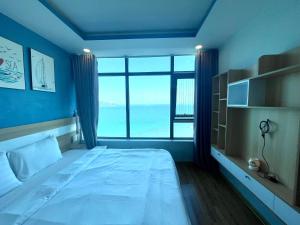 a bedroom with a large bed with a large window at Mường Thanh Luxury Viễn Triều Apartment in Nha Trang