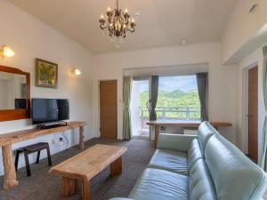 a living room with a couch and a tv at Hoshi No Terrace Motobu Yamazato in Motobu