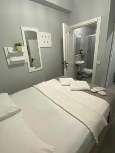 a bedroom with two white beds and a bathroom at Kadıköy Miski Amber in Istanbul