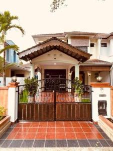 a house with a wooden gate and a porch at Modern Family Retreat by STAYco - PS4, Mini-Pool, Pool table - just 5 mins to Beach ! in Ayer Itam