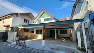 a white house with a blue roof at Chandra Home - จันทรา โฮม in Chiang Khan