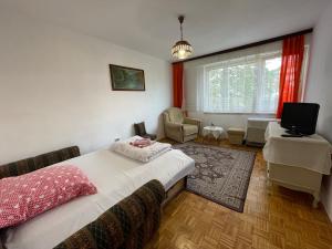 a bedroom with a bed and a chair and a television at Bronze Apartment in Sarajevo
