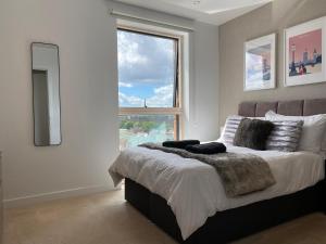 a bedroom with a bed with a large window at 7th floor apartment in London