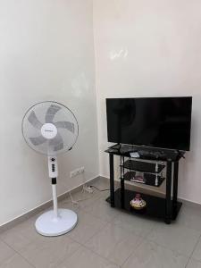 a white fan in a living room next to a tv at Appartement Spacieux chez Keur Matou - F2 Dakar in Dakar