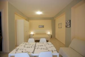 Cette chambre comprend un lit, une table et des chaises. dans l'établissement Appartamento Topazio, à Letojanni