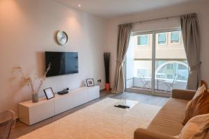 a living room with a flat screen tv on a wall at Deluxe 1 Bedroom Apartment - Elite Residence Dubai Marina - Sea View in Dubai