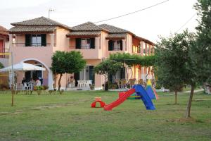 een speeltuin voor een huis met een glijbaan bij Biscoutsis Apartments & Studios in Kavos