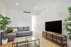 uma sala de estar com um sofá e uma televisão de ecrã plano em 3 Bedrooms - Darling Harbour - Junction St 2 E-Bikes Included em Sidney