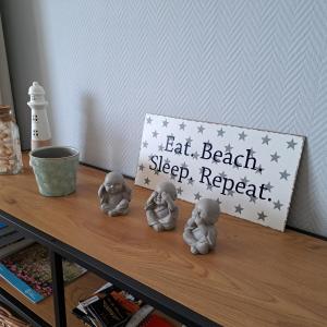 Una mesa con algunas figuras sobre una mesa con un cartel. en Appartement Residentie Amadeus met garage, en Sint-Idesbald