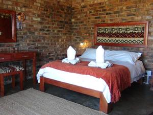 West Nest Lodge في Gobabis: غرفة نوم بسريرين وجدار من الطوب