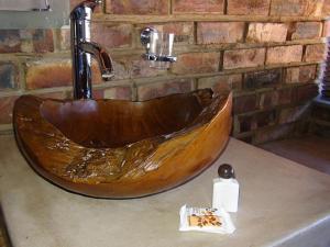 a wooden sink on a counter in a bathroom at West Nest Lodge in Gobabis