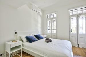 um quarto branco com uma cama grande e almofadas azuis em 3 Bedrooms - Darling Harbour - Junction St 2 E-Bikes Included em Sydney