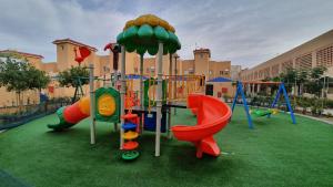 einen Spielplatz mit Rutsche und Schaukel in der Unterkunft منتجع شاطئ الدولفين للإيواء السياحي in Yanbu