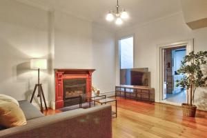 sala de estar con sofá y chimenea en 3 Bedrooms - Darling Harbour - Darghan Street 2 E-Bikes Included en Sídney